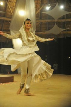 a woman in white is dancing on stage