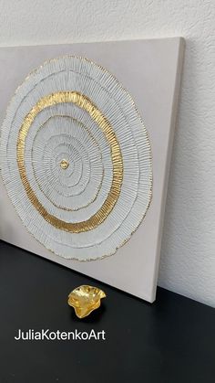 a white and gold wall hanging on a black table