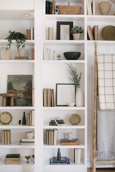 a book shelf filled with lots of books on top of a hard wood floor next to a doorway