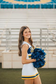 a girl in a cheerleader uniform holding a pom - pom at a football game