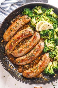 sausages and broccoli in a skillet with lemon slices on the side