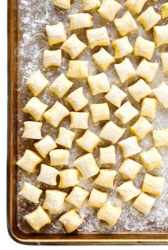 cubed potatoes on a baking sheet ready to be cut into bite sized pieces and put in the oven