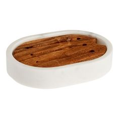 a white bowl with a wooden board in it