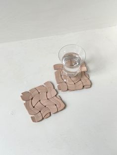 Undyed woven leather coasters with curvy water glass. Rise Art, Leather Coasters, Woven Placemats, Cardboard Art, Desk Set, Sustainable Brand, Leather Goods, Coaster Set, Nature Art