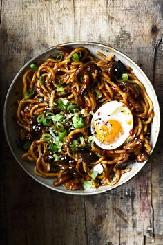 a bowl filled with noodles and an egg on top