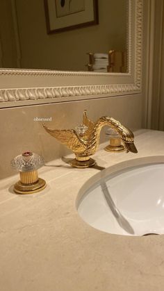 a bathroom sink with a bird shaped faucet next to it