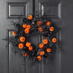 an orange and black wreath on the front door