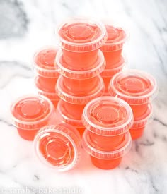 a pile of orange plastic cups sitting on top of a marble countertop next to each other