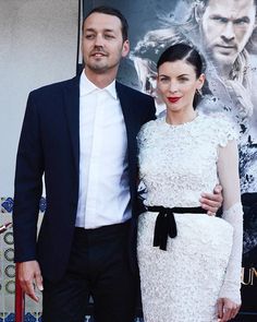 a man and woman standing next to each other on a red carpet at a movie event