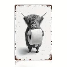 a black and white photo of a cow holding a roll of toilet paper