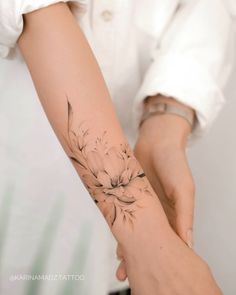 a woman's arm with a flower tattoo on it