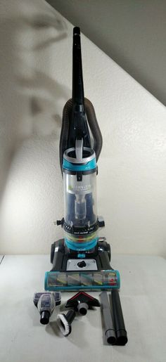 a blue and black vacuum sitting on top of a white table next to other items