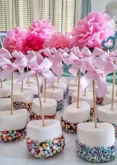 cupcakes with pink bows and candy on sticks