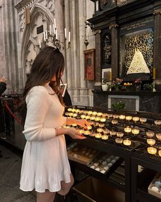 a woman standing in front of a table filled with cupcakes