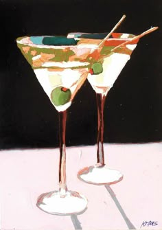 two martini glasses with olives on the rim