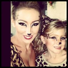 two women with makeup on their faces are posing for a photo while one woman has her face painted like a cat