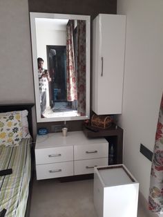 a bedroom with a bed, dresser and mirror