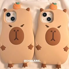 two phone cases that are shaped like animals with oranges on their heads and ears