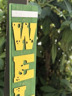 a green and yellow sign with the word w is for wild on it's side