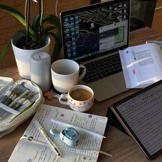 an open laptop computer sitting on top of a desk next to a cup of coffee