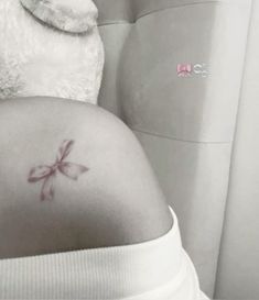 the back of a pregnant woman's stomach with a small tattoo on her belly