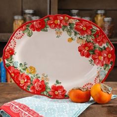 two oranges sitting on top of a wooden table next to a red and white plate