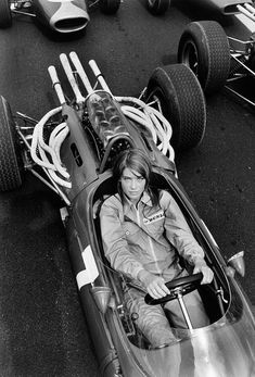 a man sitting in a race car on the street