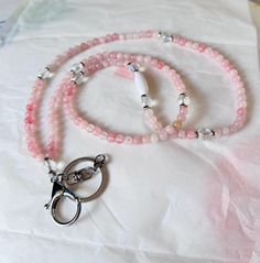 🍎Handmade Pastel pink Rose quartz and crystal lanyard!  This is a one of a kind lanyard made for my back to school sale! Get it while you can in silver, gold, or Rose Gold accents! All orders come with a gift from me!  It's made with 6mm Rose Quartz beads in pastel pink.  Made 18.5" long with a silver lobster clasp and accents.  The closure is a strong breakaway clasp in white. ✨I love making custom orders! If you would like a custom look, please reach out to me. I make all my products myself, by hand. They are not purchased on cheap product apps, like many others, and resold. Be careful of items that are pretending to be "handmade" but are not. ❤️ Thank you for supporting the true handmade crafters here. Lanyard Crystals, White Rose Quartz Spiritual Necklaces, Rose Quartz Necklace Rope, Couleur Rose Pastel, Rose Quartz Healing Necklace Hand-strung, Hand-strung Pink Rose Quartz Necklace, Zodiac Stones, Rose Gold Accents, Nurse Badge Holders