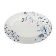 a white plate with blue flowers and leaves on the rim, against a white background