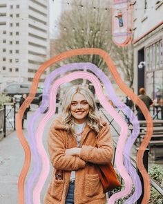 a woman standing in front of a colorful frame