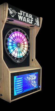 a dart board with darts in front of it and a tv screen on the side