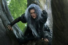 a woman with grey hair standing in the woods