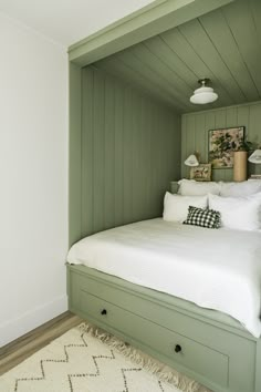 a bedroom with green paneling and white bedding