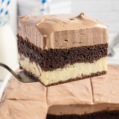 a piece of cake being held by a fork with chocolate frosting on the top