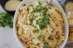 a white bowl filled with pasta and garnished with parsley