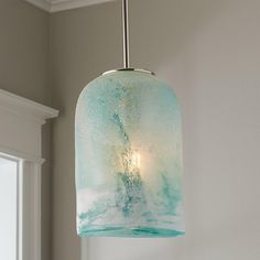 a light fixture hanging from the ceiling in a room with white walls and window sill