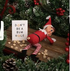 an elf is sitting in front of a sign that says don't be a bum hole