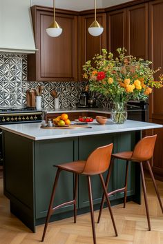 a kitchen island with two chairs next to it and flowers on the counter in front of it