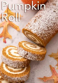 pumpkin roll with powdered sugar on top next to fall leaves and an apple in the background