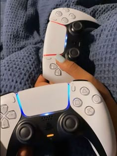 two people holding wii remotes in their hands with the controllers on top of them