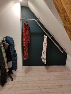 there is a coat rack in the corner of this room with clothes hanging on it