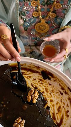 a woman is holding a spoon over a chocolate dessert