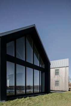 the house is made out of black wood and has large windows on each side of it