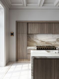 an elegant kitchen with marble counter tops and wooden cabinetry, along with white walls