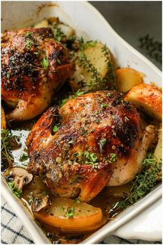 chicken and potatoes in a baking dish with herbs