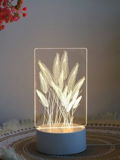 a light that is sitting on top of a table with some plants in the background