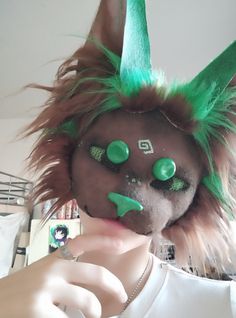 a close up of a person with green hair and monster ears on their head wearing a white t - shirt