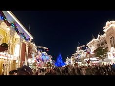 people are walking through an amusement park at night