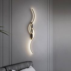 a wall light that is on the side of a wall next to a bed in a room