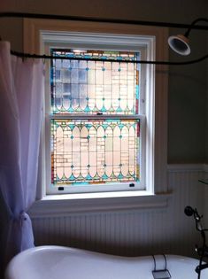 a bathroom with a window that has stained glass on it